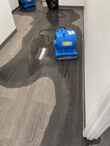 Equipment cleaning water off floor during water damage restoration